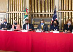 Mexican Embassy signing documents at red table