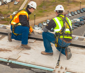 workers kneeling on roof