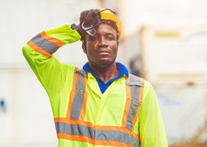 worker wiping forehead in hot environment